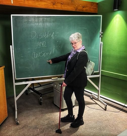I’m standing in front of a green chalkboard pointing to words I’d just written that say: Disabled AND awesome