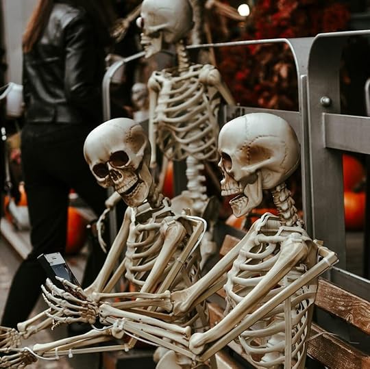 a couple of skeletons sitting on top of a wooden bench