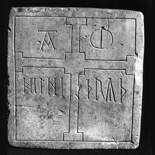 Dressed and incised square stone showing runes and a cross