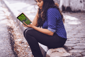 Woman sitting on the curb, absorbed in reading Staccato Passage, by Joslyn Chase