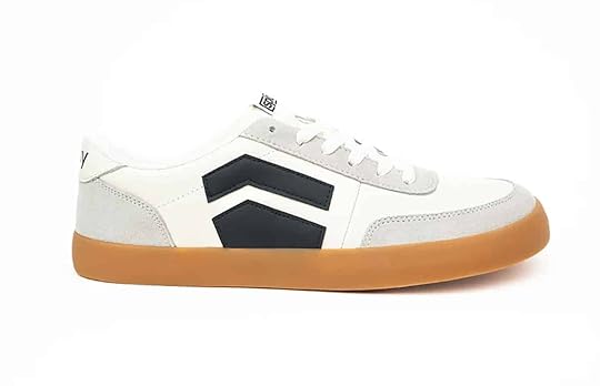 A side view of a white Splay shoe with black stripes.