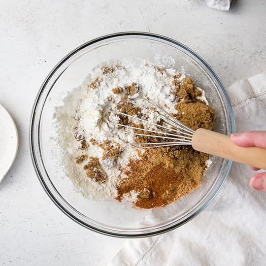 Close-up of dry ingredients being whisked together in a clear bowl to make pancake batter.