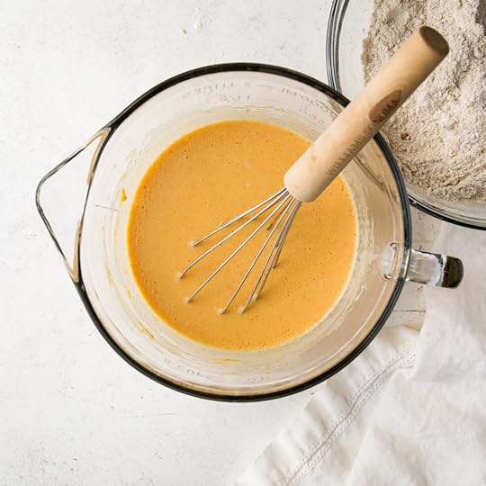 Wet ingredients (pumpkin puree, egg, milk, oil and vanilla being whisked until smooth in a large glass measuring cup for homemade pancake batter.