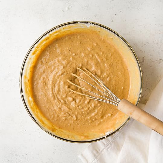 Final pumpkin pancake batter in a mixing bowl, showing the thick smooth texture after the wet and dry ingredients have been lightly combined.