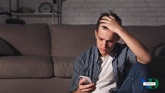 A male teen is looking at his phone.