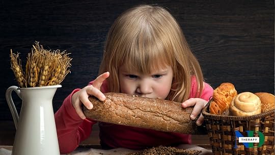 A girl holds a large piece of bread.