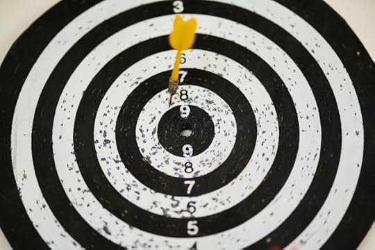 Yellow dart hitting the center of a black and white target, symbolizing focus and the 5 most powerful mantras for success