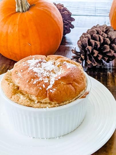 The pumpkin soufflé on a plate with pumpkin and pinecone in the background - a Thanksgiving desserts besides pie