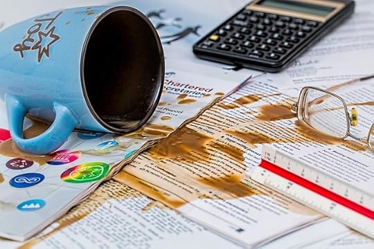 Coffee spilt over papers on desk representing entrepreneur mistakes.