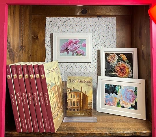 The Austens on a shelf at Lady Luck next to framed paintings of flowers