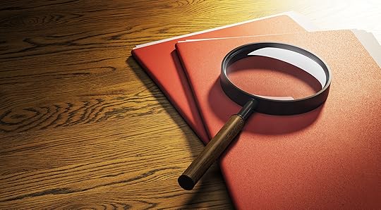 Picture of a magnifying glass lying atop file folders