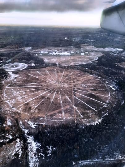 Snow revealing a large radial pattern in a round field.
