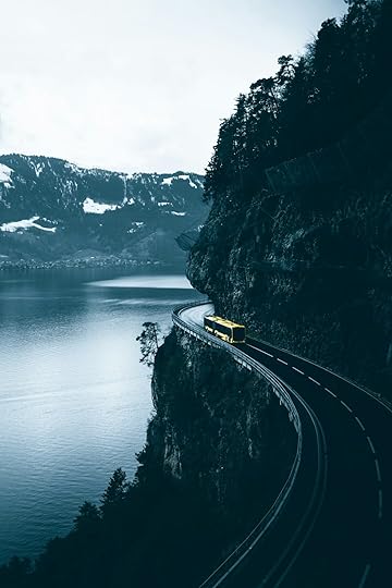 yellow car on road near body of water during daytime
