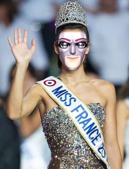 This may contain: a woman wearing a mask and holding her hand up in the air as she walks down the runway