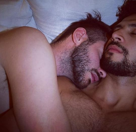 This may contain: two men are sleeping together in the bed