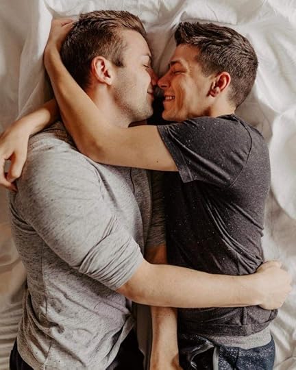 This may contain: two men hugging each other while laying in bed