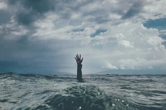 A hand reaching out of chaotic water