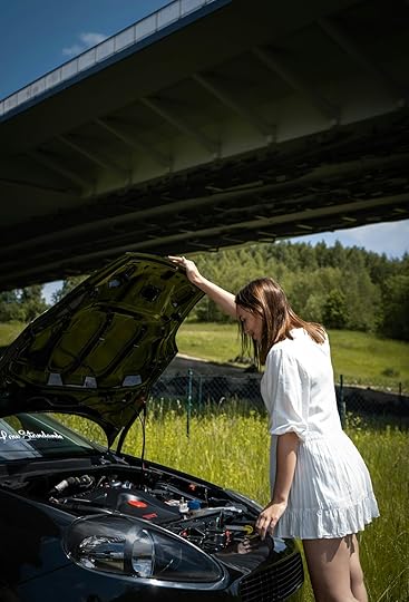 woman in white dress standing beside black car during daytime