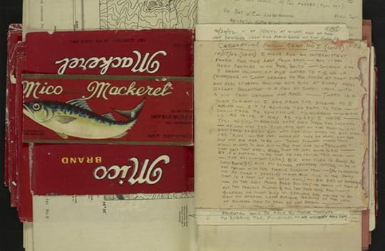 An upside down red label from a can of mackerel with its label lined with tiny handwriting.