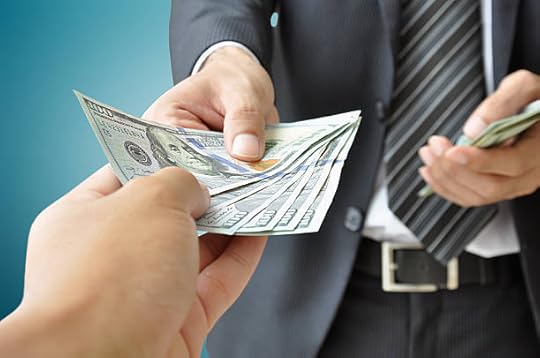 Close-up of a person handing dollar bills to another hand.
