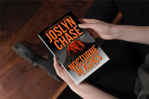 Person getting ready to read Nocturne in Ashes, by Joslyn Chase