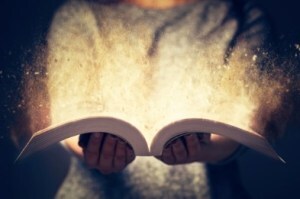 Person holding a glowing open book