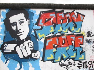 A section of the Berlin Wall with graffiti guy saying, 