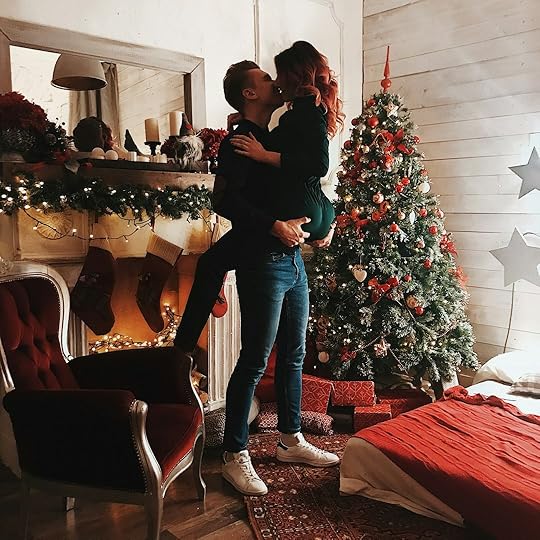 man carrying woman beside green Christmas tree