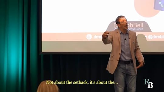 Full-body shot of a presenter on stage mid-gesture with subtitle about setbacks.