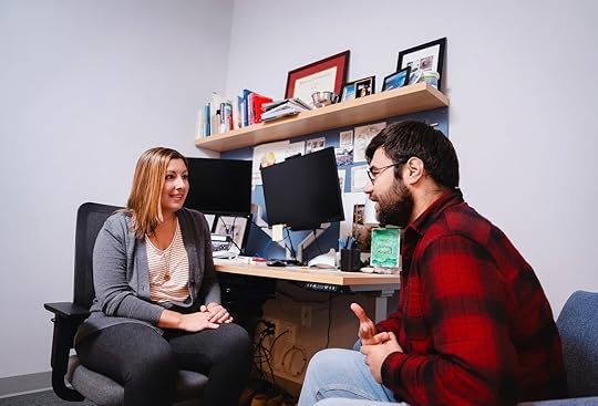 Two people are walking out of the Student Health Services building at Boston University.