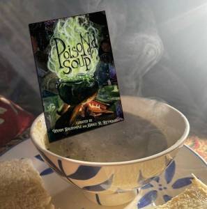 Image shows a steaming bowl of soup with a copy of Poisoned Soup 'dunked' into it
