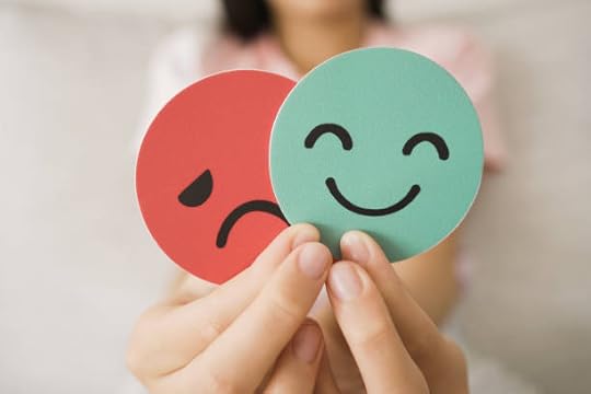 Hands holding happy and sad face cards, reflecting emotional change and the question: do subliminals really work for shifting mood and mindset.