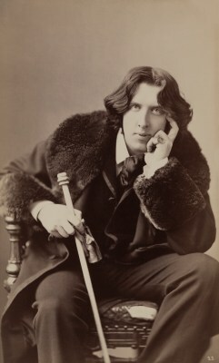 three quarter length sepid photo of Oscar Wilde seated