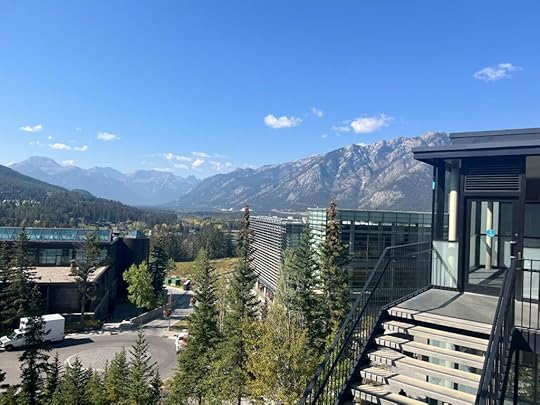 Under blue skies, a mountain view with modern buildings in the foreground. Photo is taken from a high angle.