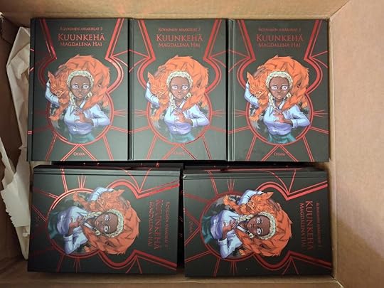 Pahvilaatikko, jossa viisi kappaletta Kuunkehiä. Kirja on musta, kiiltävän punaisin aksentein, keskiössä tummaihoinen ja valkotukkainen noitatyttö, jonka harteilla on vihaisen näköinen punainen kissa.