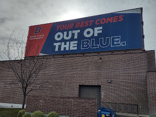 Image of a giant billboard atop a building reading "Your Best Comes Out of the Blue"