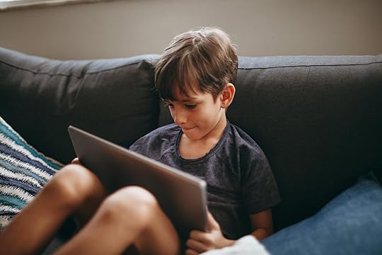 young boy engaging with tablet on cozy sofa - rehumanising parenting