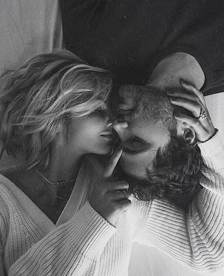 This may contain: a man and woman kissing each other in black and white