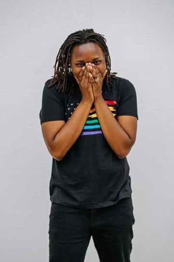 a woman in a gay pride shirt covering her mouth