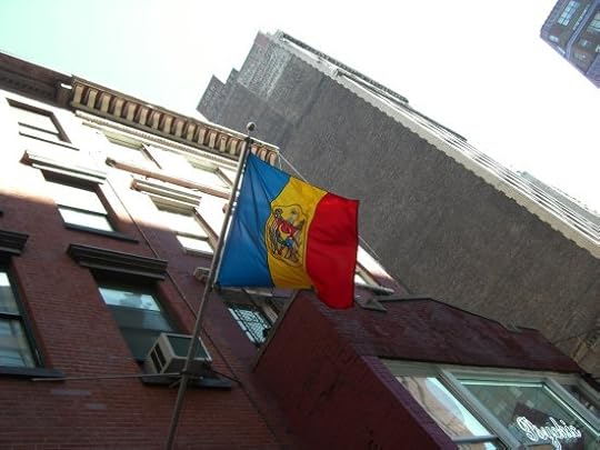 Moldovan flag flying outside a brick building in an urban setting.