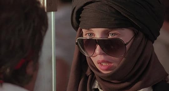Isabelle Adjani wears sunglasses and a headscarf, her mouth hanging open slightly.