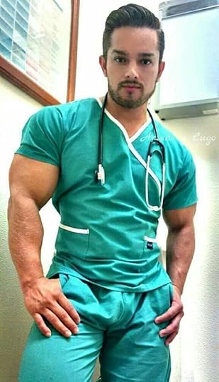 This may contain: a man in green scrubs and a stethoscope standing next to a wall