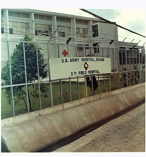 Exterior view of the U.S. Army Hospital in Saigon, featuring a sign for the 3rd Field Hospital and a fenced area with trees.