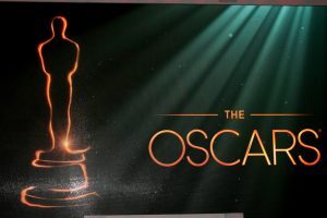 Oscar logo and statuette on green and black background