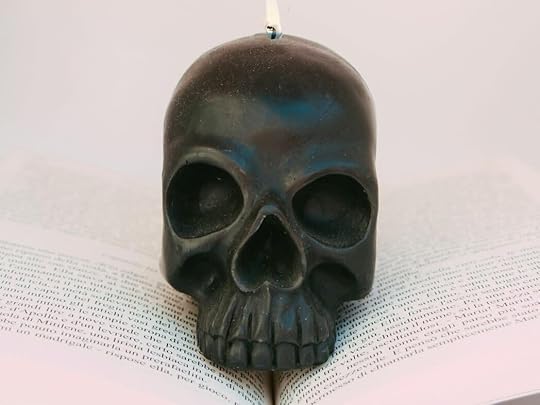 black skull with white candle on head figurine