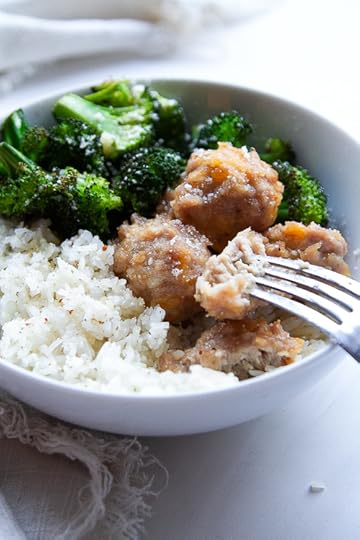 Baked chicken meatballs in a bowl with seasoned rice and roasted broccoli.