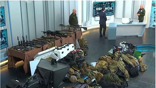 A group of men standing next to a table full of gunsAI-generated content may be incorrect.