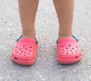 child wearing a pair of pink crocs