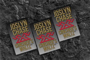 Three copies of Cincher's Waltz by Joslyn Chase on black volcanic rock