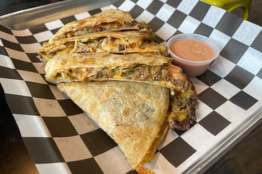 Smashadilla from Between Two Buns, filled with chopped smash patties, cheese, maduros, smash sauce, potato sticks, lettuce, tomato, and pickles.